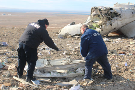 Two investigators examine wreckage at the occurrence site.