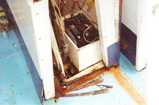 Photo of the disintegration due to dry rot of door frame and console base, and corrosion in way of irregularly shaped hole in main deck