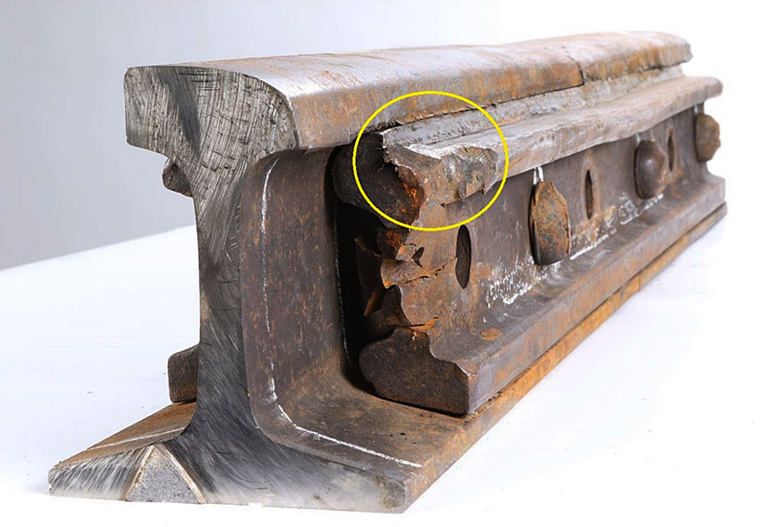 Gauge bar and bolt hole with wheel flange impact damage on the corner of the joint bar