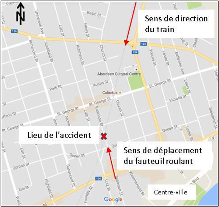 Figure 2. Carte montrant le lieu de l'accident ainsi que le sens de déplacement du train et du fauteuil roulant dans le centre-ville (Source : Google Maps, avec annotations du BST) 