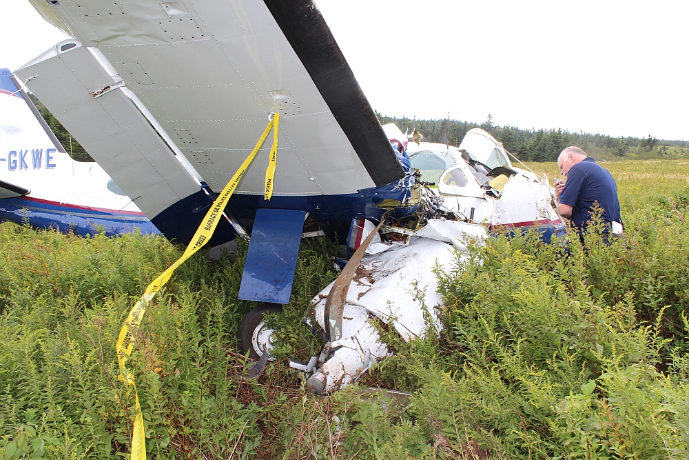 Photo of a TSB investigator examining wreckage on Grand Manan Island, New Brunswick
