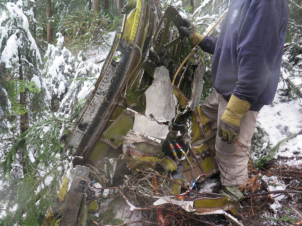 Photo of investigator examining  wreckage at the accident site