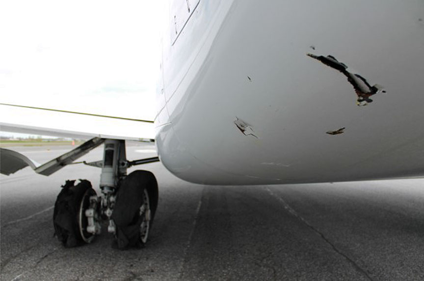 Vue des dommages au train d'atterrissage principal gauche et au fuselage central arrière