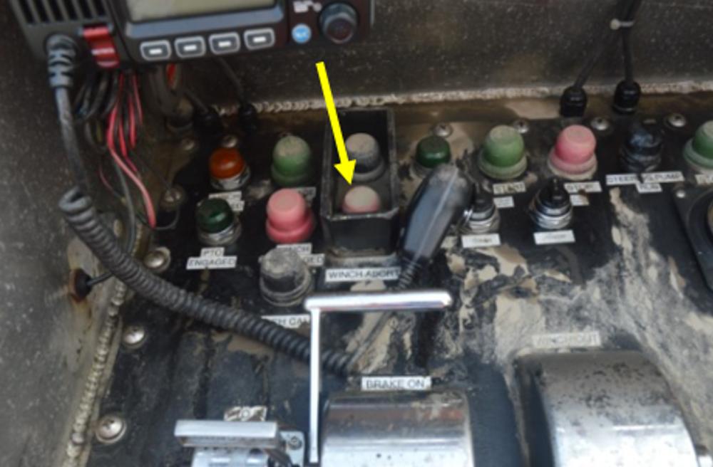 Dispositif de largage de remorque au poste de conduite du pont supérieur arrière, bouton de largage de remorque indiqué par la flèche jaune (Source : BST)