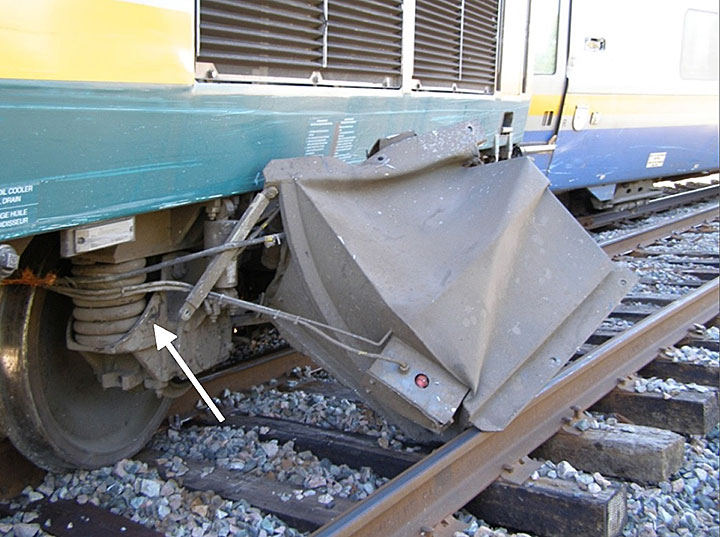 Image du marque d'impact sur le longeron du bogie arrière de la locomotive VIA 915 et coffre de batterie détaché