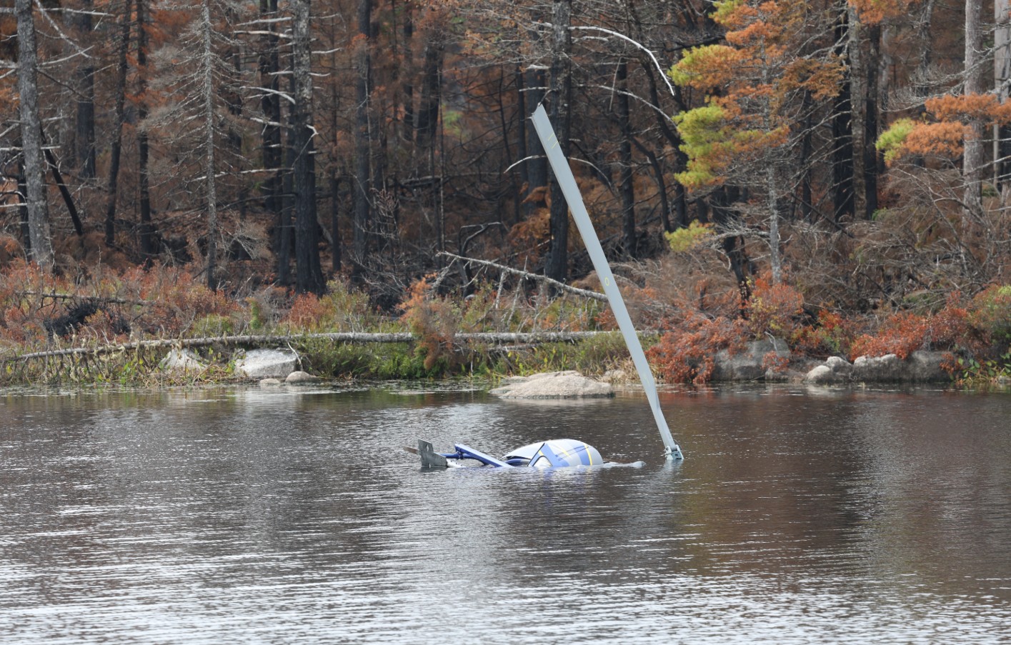 Figure 1. The occurrence helicopter in Fivefinger Lake, Nova Scotia, partially submerged, with one main rotor blade extending above the water surface (Source: Professional photographer    from the Nova Scotia Department of Natural Resources and Renewables)
