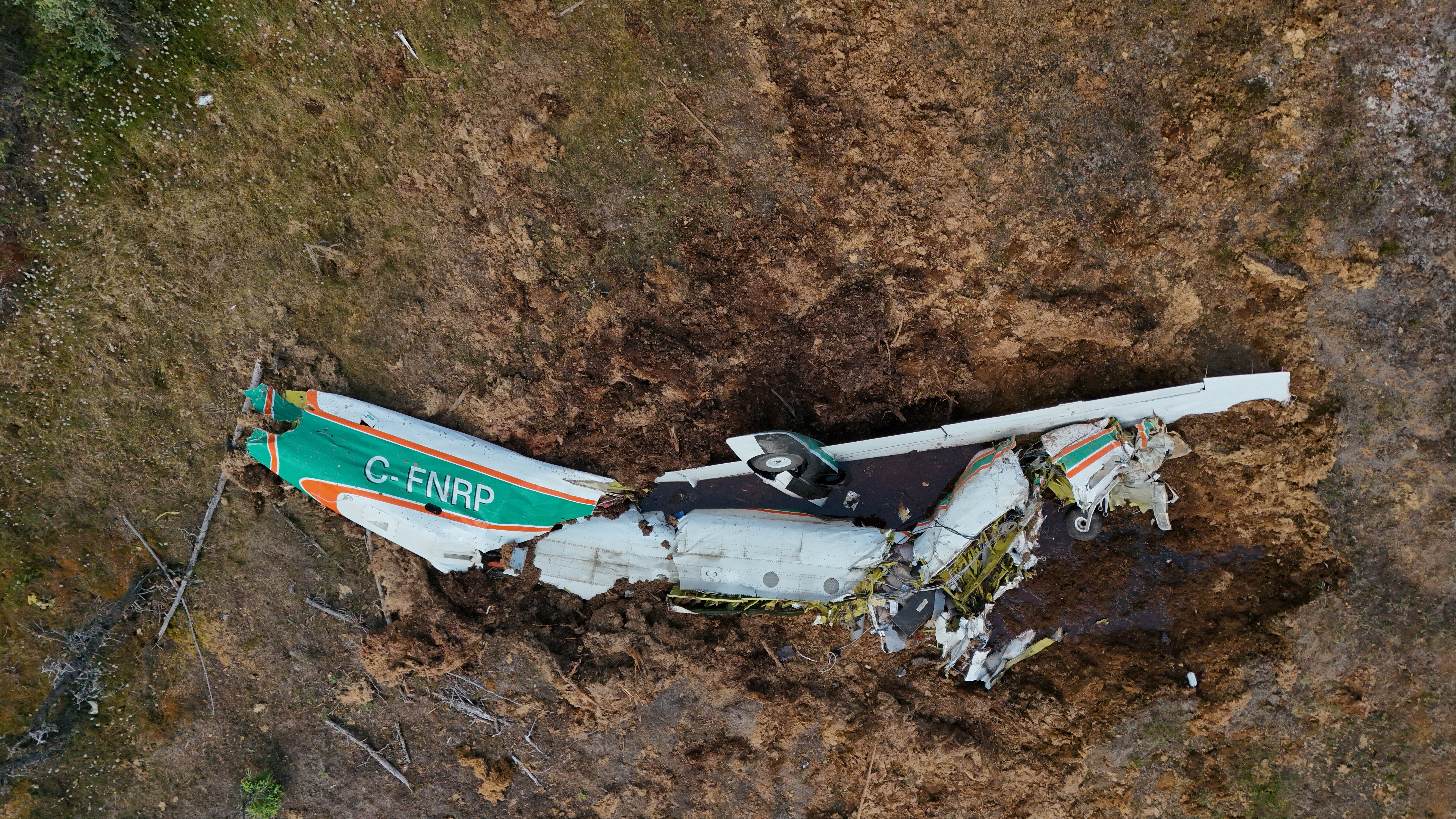 Photo 2 : Vue aérienne en gros plan de l’épave à la suite de la désintégration en vol et la collision avec le relief du 24 juin 2026 près de l’aéroport de Fort Simpson (Territoires du Nord-Ouest) (Source : Bureau de la sécurité des transports du Canada)